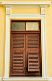 Brown wooden shutters on the yellow wall