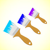 Three colour paint brushes on yellow smooth background