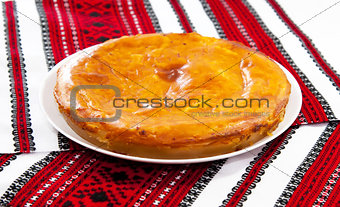 Onion and cheese pie on traditional ukrainian towel