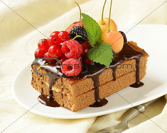 chocolate cake with berries (raspberry, currant, cherry) and chocolate sauce