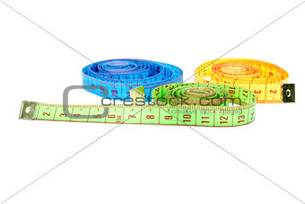Three rolled measuring tapes of different colors