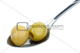 Two marinated pitted green olives in the small metal spoon