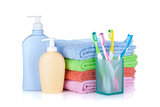 Four colorful toothbrushes, cosmetics bottles and towels