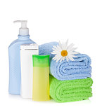 Shampoo and gel bottles with towels and flower