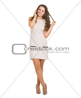 Full length portrait of happy young woman talking cell phone