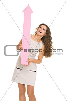 Full length portrait of smiling young woman pointing up on copy 