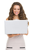 Happy young woman using laptop