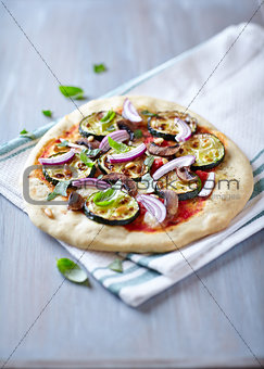 Pizza with grilled zucchini and pine nuts