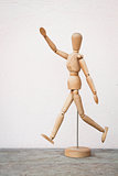 Wooden figure pose as happy jumping forward