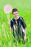Smiling boy catching butterflies in the meadow