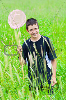Smiling boy catching butterflies in the meadow