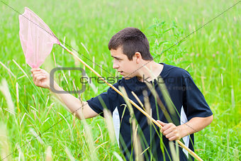 Boy catching butterflies in the meadow