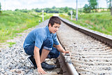 Boy puts stones on railway tracks