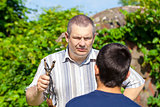 Angry man with slingshot in hand against the boy