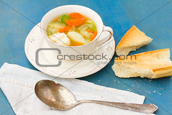 Fish soup with silver spoon
