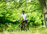 Cyclist Riding the Bike on the Trail in the Forest