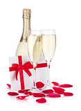 Two champagne glasses, letter and rose petals