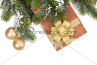 Gift box and christmas decor under snowy fir tree