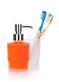 Two colorful toothbrushes and liquid soap