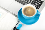 Blue coffee cup, laptop and office supplies