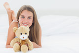 Cheerful girl holding a teddy bear