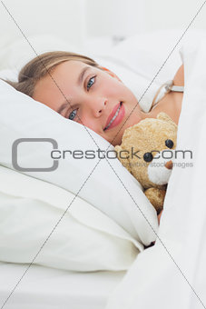 Cute girl relaxing with her teddy bear