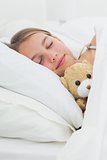 Cute girl sleeping with her teddy bear