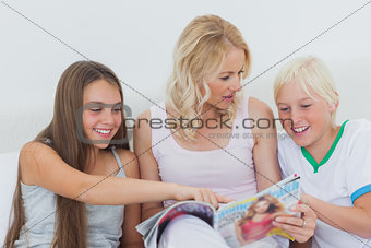 Girl pointing at a magazine in her mother hands