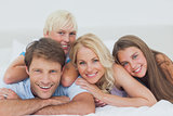 Smiling family lying on bed