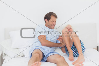 Father tickling son