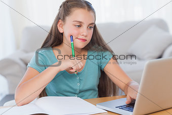 Thoughtful girl doing her homework