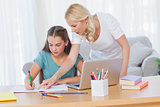 Mother helping her daughter to do her homework