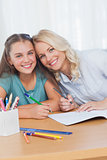 Mother helping daughter with homework in living room