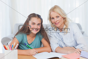 Woman helping her daughter doing her homework