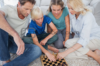 Portrait of a cute family playing chess