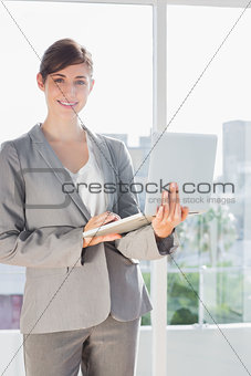 Smiling businesswoman holding laptop