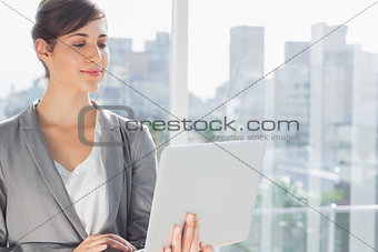 Smiling businesswoman working on laptop