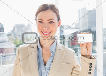 Smiling businesswoman showing blank business card