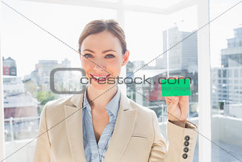 Smiling businesswoman showing green business card