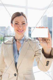 Smiling businesswoman holding up blank business card
