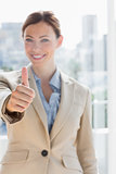 Pretty businesswoman giving thumb up