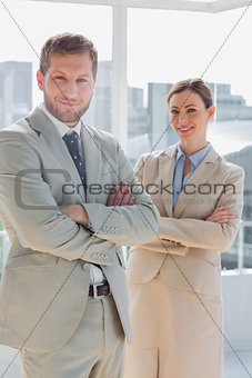 Happy business partners with arms crossed