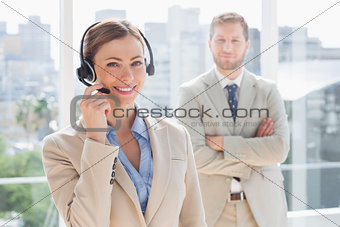 Happy call centre agent with colleague behind her