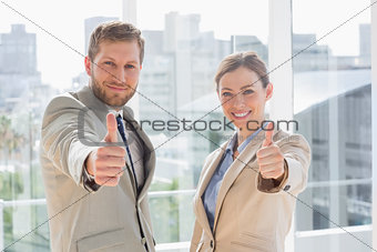Smiling business team giving thumbs up