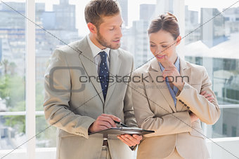 Business partners going over document on clipboard