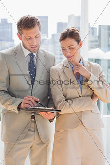Business people going over document on clipboard