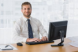 Businessman sitting at desk smiling