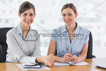Happy businesswomen working together and smiling at camera
