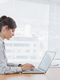 Businesswoman typing on her laptop at desk