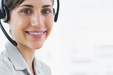 Brunette call centre agent smiling at the camera